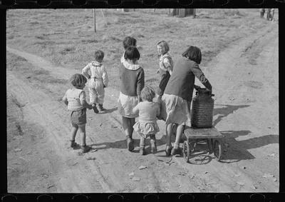 Children of migratory workers, hauling water, American River camp,…, California, 1936