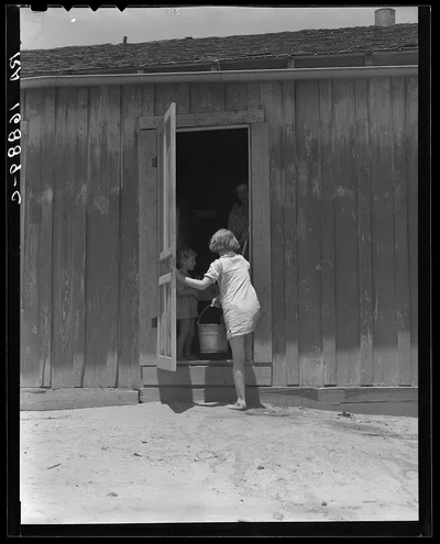 Child of Texas sharecropper carrying water, 1937