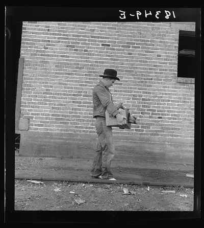 Cotton picker during strike carrying his Farm Security Administration…, California, 1938