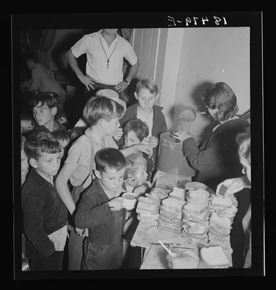 The children crowd and push to reach the refreshments at Halloween…, California, 1938