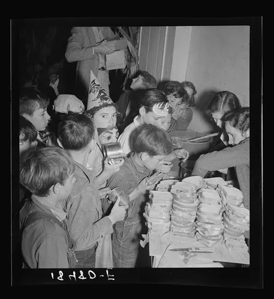 The children crowd and push to reach the refreshments at Halloween…, California, 1938