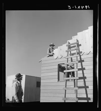 Father and son, recent migrants to California, building house in…, 1939