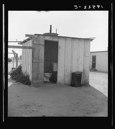 Toilet for ten cabins, men, women, and children. In Arkansawyers auto…, California, 1939