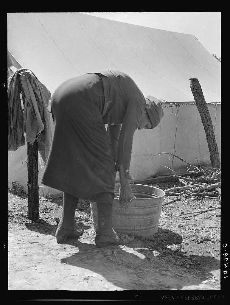 A grandmother washing clothes in a migrant camp. Stanislaus County,…, California, 1939