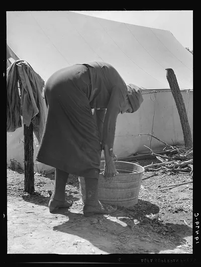 A grandmother washing clothes in a migrant camp. Stanislaus County,…, California, 1939