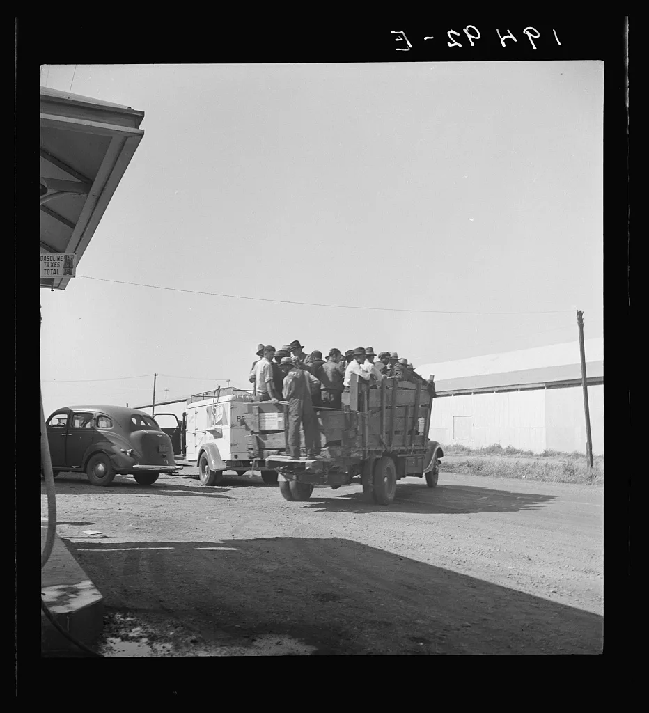 Labor contractor's truck with gang of pea pickers, pulled up for gas.…, California, 1939