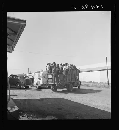 Labor contractor's truck with gang of pea pickers, pulled up for gas.…, California, 1939